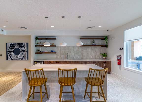 A kitchen with a table and chairs in the middle.