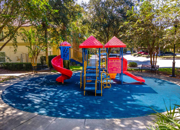 a childrens play park with a blue pool and red slides