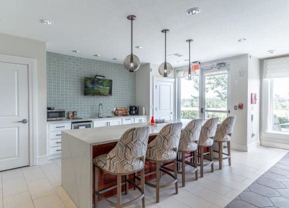 a kitchen with a long counter and a tv on the wall
