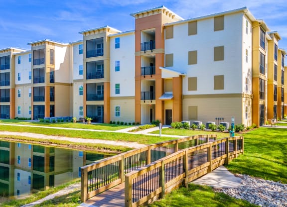 an apartment building with a pond in front of it