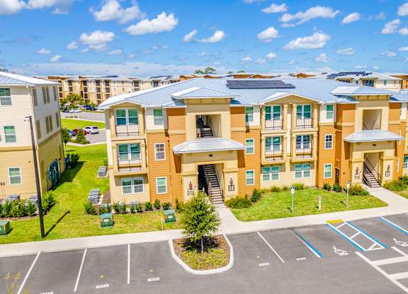A large apartment complex with a parking lot in front.