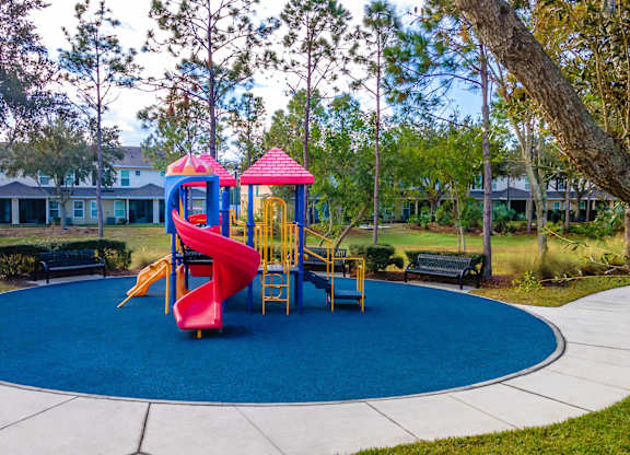 A playground with a red slide and a yellow slide.
