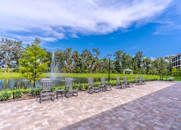 A park with a fountain, benches, and trees.