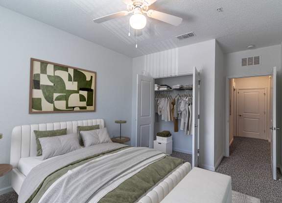 A bedroom with a large bed and a painting on the wall.