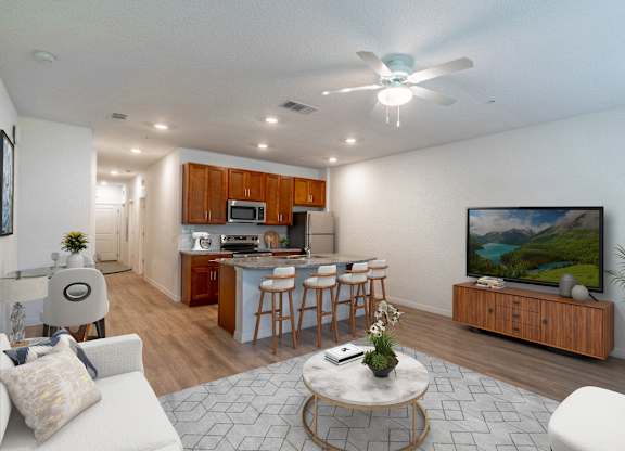 A living room with a television and a kitchen area in the background.