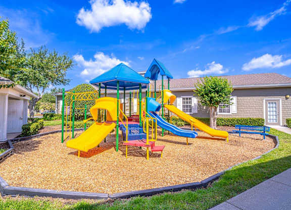 A playground with a blue and yellow slide and a red and yellow platform.