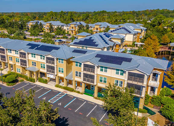A large apartment complex with a parking lot in front.