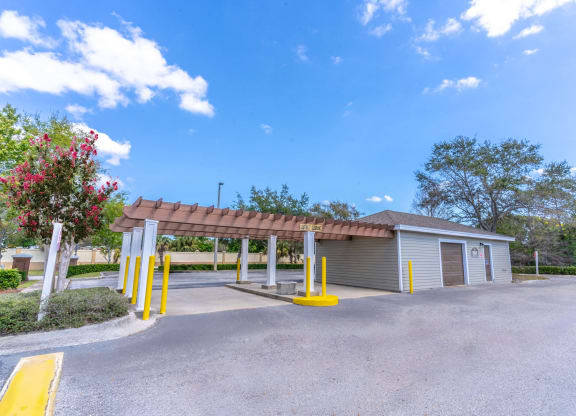 a parking lot with a building and a covered parking lot