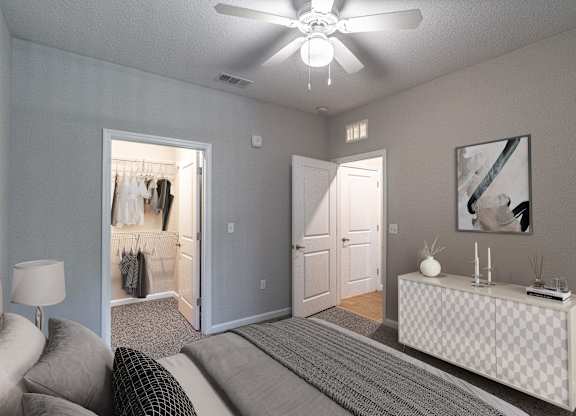 A bedroom with a bed, a dresser, and a ceiling fan.