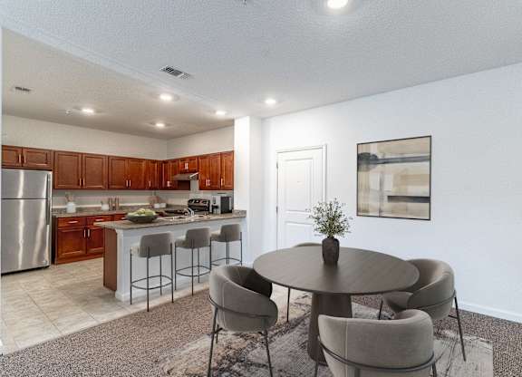 A modern kitchen with a dining table and chairs.