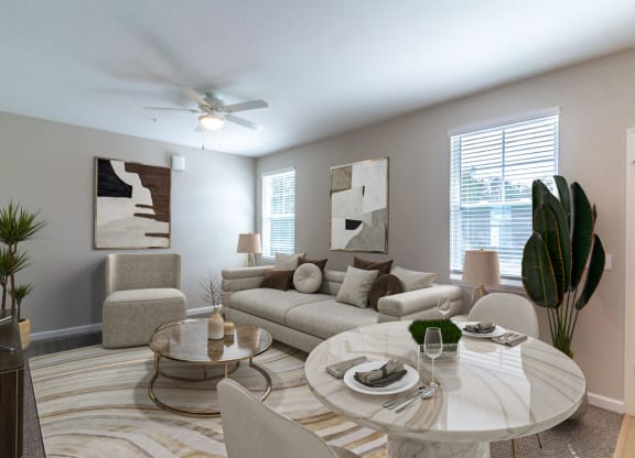 a living room with couches and a round table and a ceiling fan
