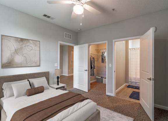 A bedroom with a large bed and a ceiling fan.