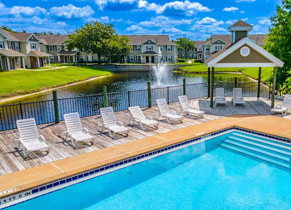 A resort style pool with gazebo and lake in the background