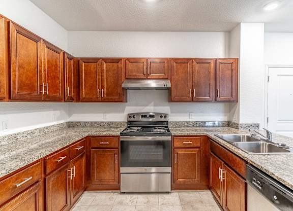 A kitchen with wooden cabinets and granite countertops.
