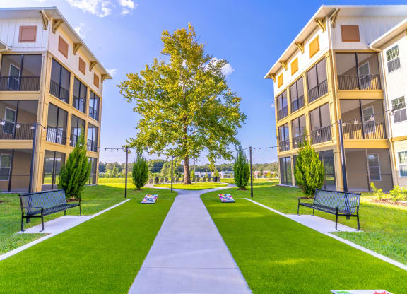 a park with benches in front of an apartment building