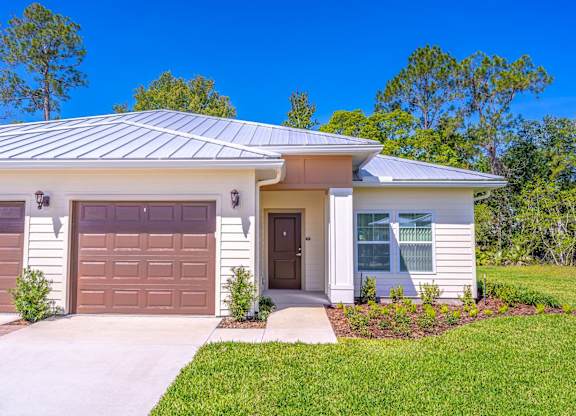 A house with a brown garage door and a white house with a brown door.