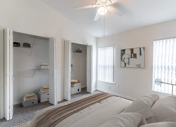 A bedroom with a large bed and a ceiling fan.
