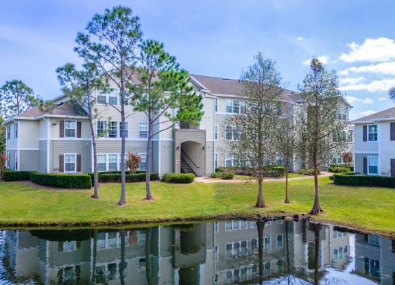 an apartment building with a pond in front of it