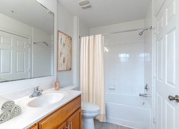 A white bathroom with a toilet, sink, and bathtub.