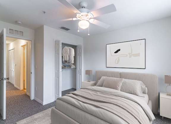 A bedroom with a large bed and a ceiling fan.