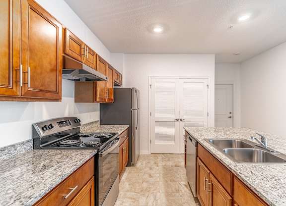 A kitchen with granite countertops and wooden cabinets.