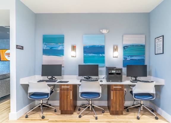 A room with a white desk and two chairs.