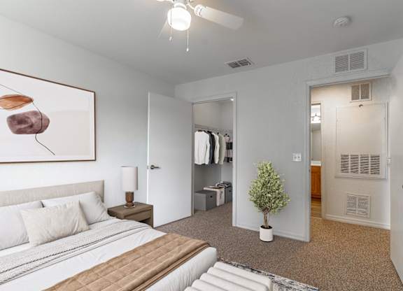 A bedroom with a large bed and a painting on the wall.