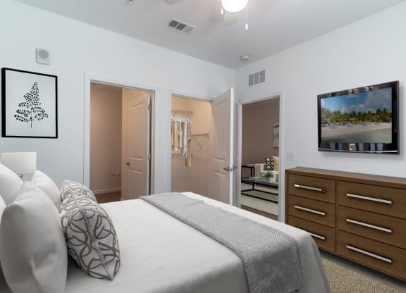 a bedroom with a large white bed and a tv