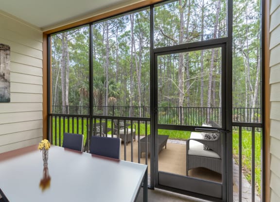 a room with a table and chairs and a sliding glass door