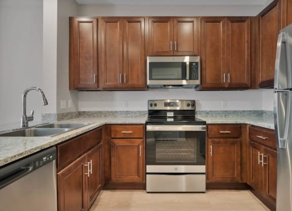 a kitchen with wooden cabinets and stainless steel appliances