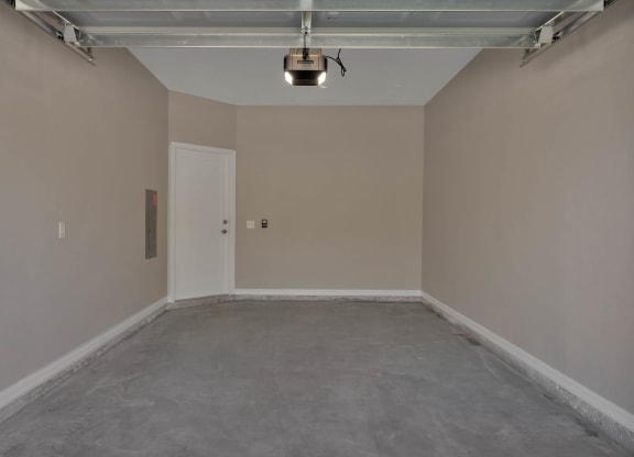 an empty room in a garage with a light on the ceiling