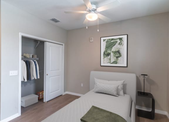 a bedroom with a bed and a ceiling fan