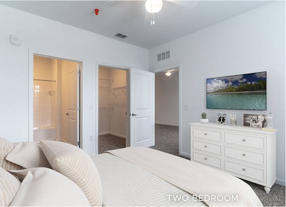 A bedroom with a bed, dresser, and two doors.