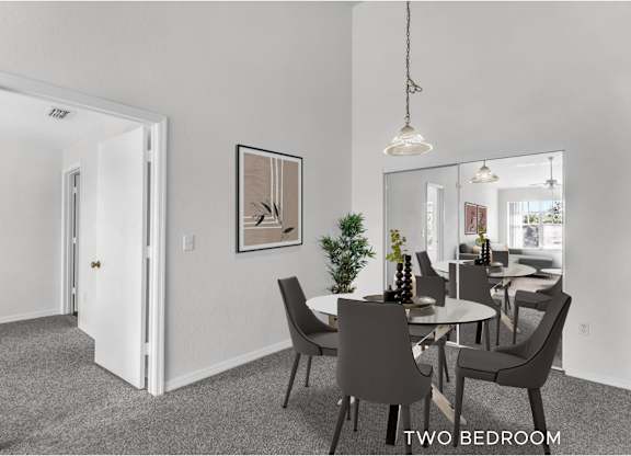 A dining room with a table set for two and a mirror on the wall.