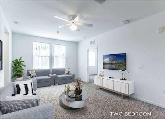 A living room with a grey couch, a white armchair, a coffee table, and a painting on the wall.