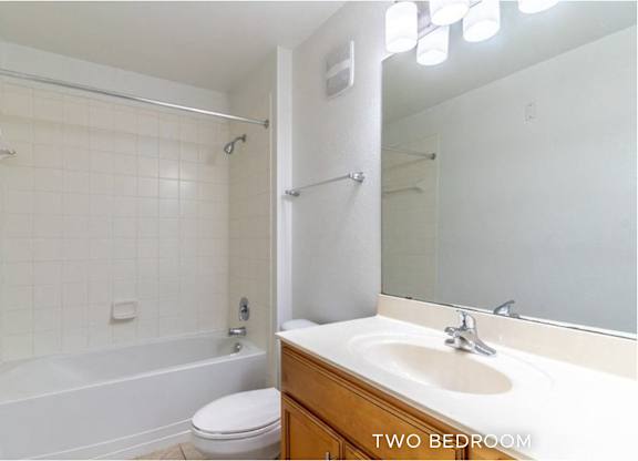 A white bathroom with a toilet, sink, and bathtub.