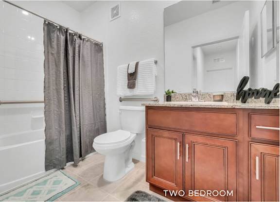 A bathroom with a toilet, sink, and shower.