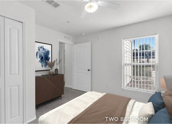 A bedroom with a bed, a painting, and a window with a view of a balcony.