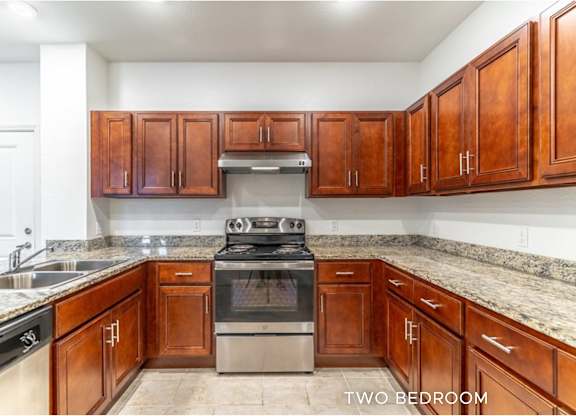 A kitchen with brown cabinets and a stove top oven.