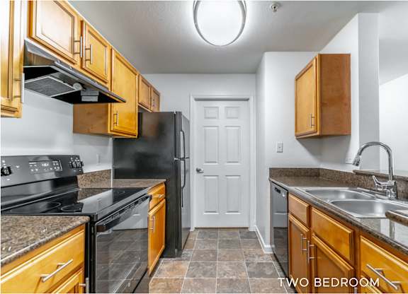 A kitchen with black appliances and wooden cabinets.