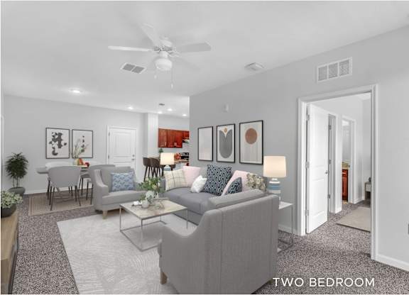A living room with a grey couch and a glass coffee table.