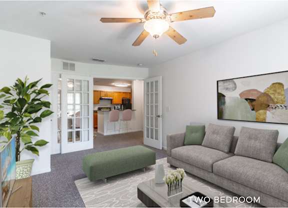 A living room with a grey couch and a ceiling fan.