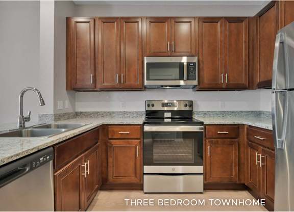 A kitchen with brown cabinets and a stainless steel refrigerator.