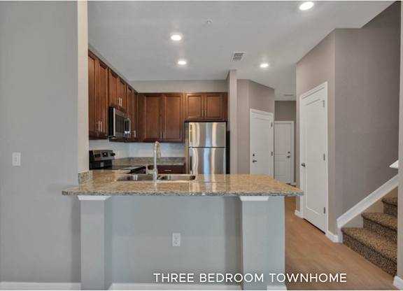 A kitchen with granite countertops and wooden cabinets.