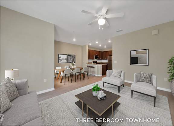 A living room with a grey couch, a coffee table, and a ceiling fan.