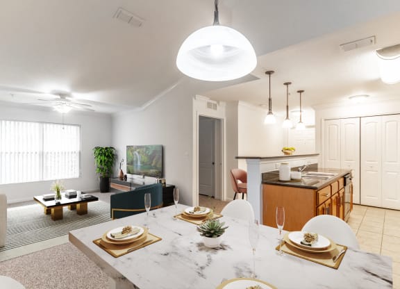 an open living room and dining room with a marble table and chairs and a kitchen