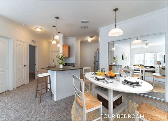 A well-lit, spacious kitchen and dining area in a four bedroom home.