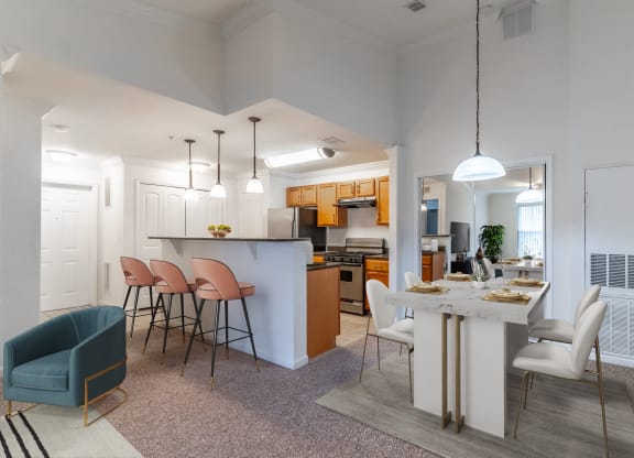 an open kitchen and living room with a dining table and chairs