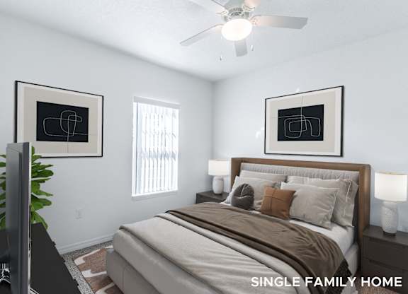 A bedroom with a bed, a television, and two framed pictures on the wall.