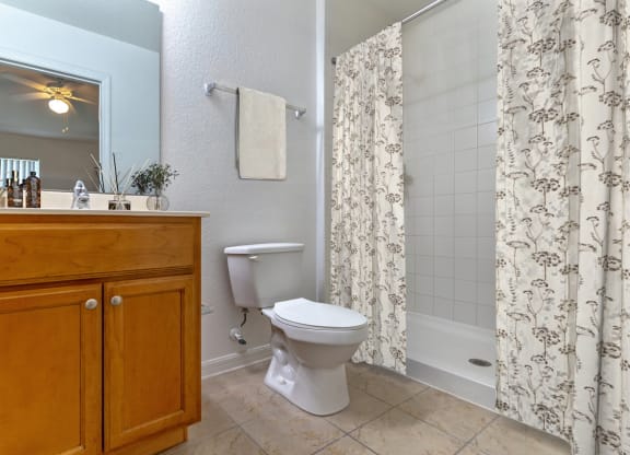 a bathroom with a white toilet next to a bathtub with a shower curtain